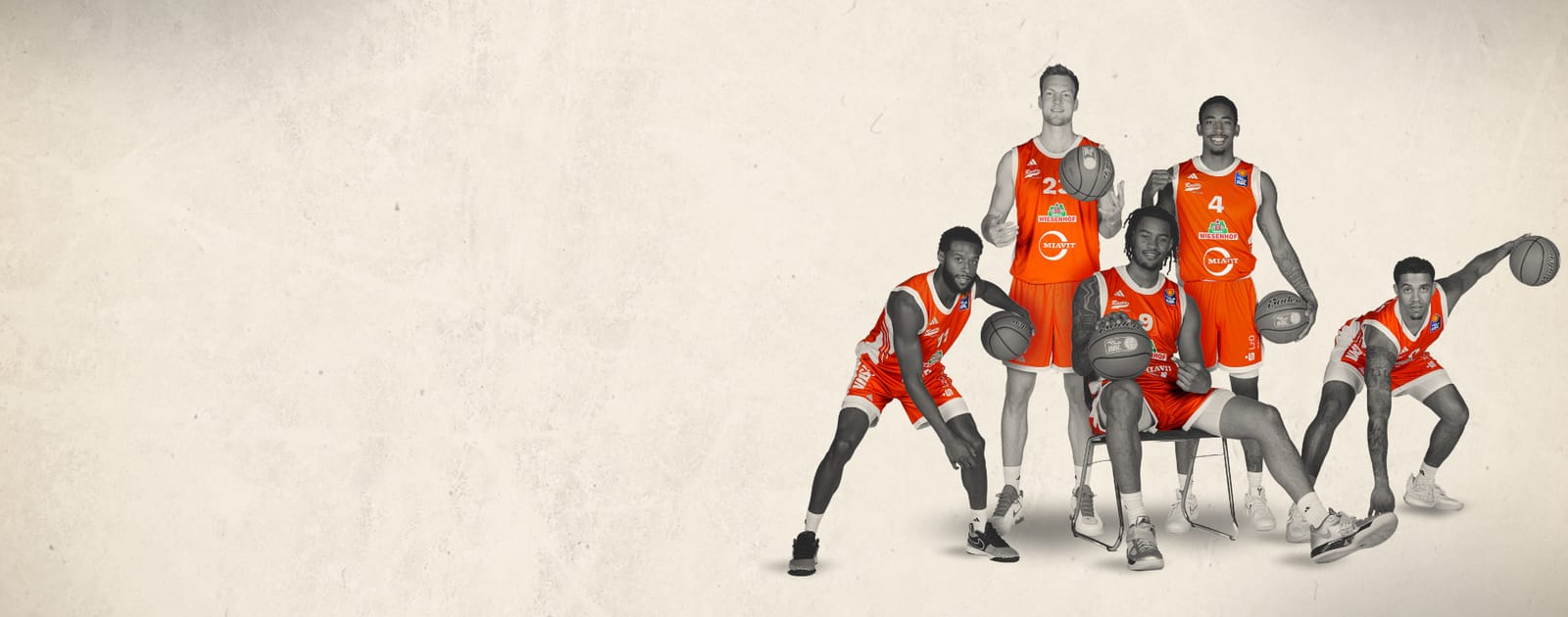 5 RASTA Vechta Basketballspieler posieren in orangen Spielertrikots