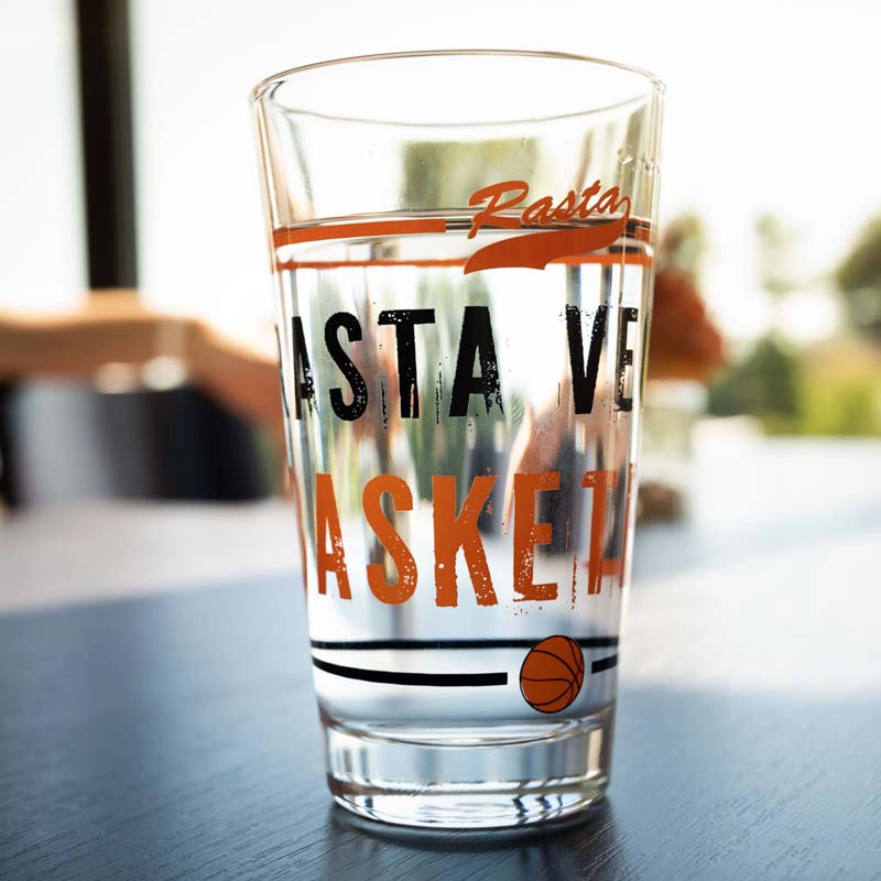 1 Glas Wasserglas "RASTA" 2er Set mit Rasta Vechta Schriftzug  in schwarz Basketball in orange orangem Strich und Rasta sowie schwarzen Strich unten mit Basketball als Bild.