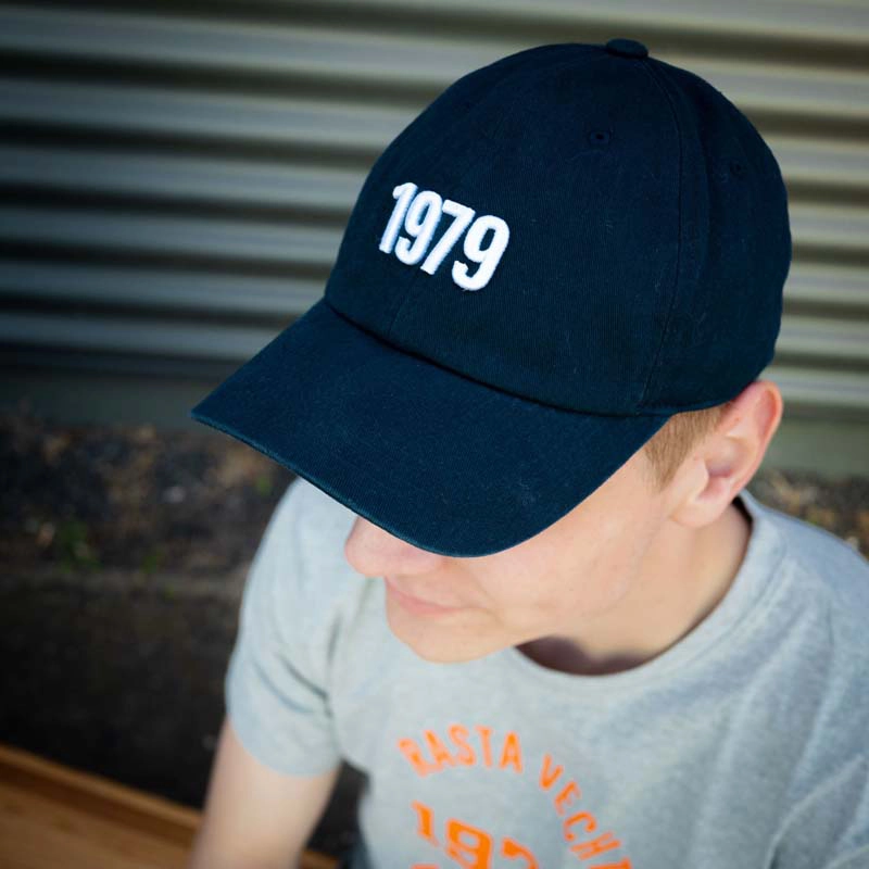 Mann mit Cap "1979" in marineblau von vorne mit Zahl 1979 aufgestickt in weiß.