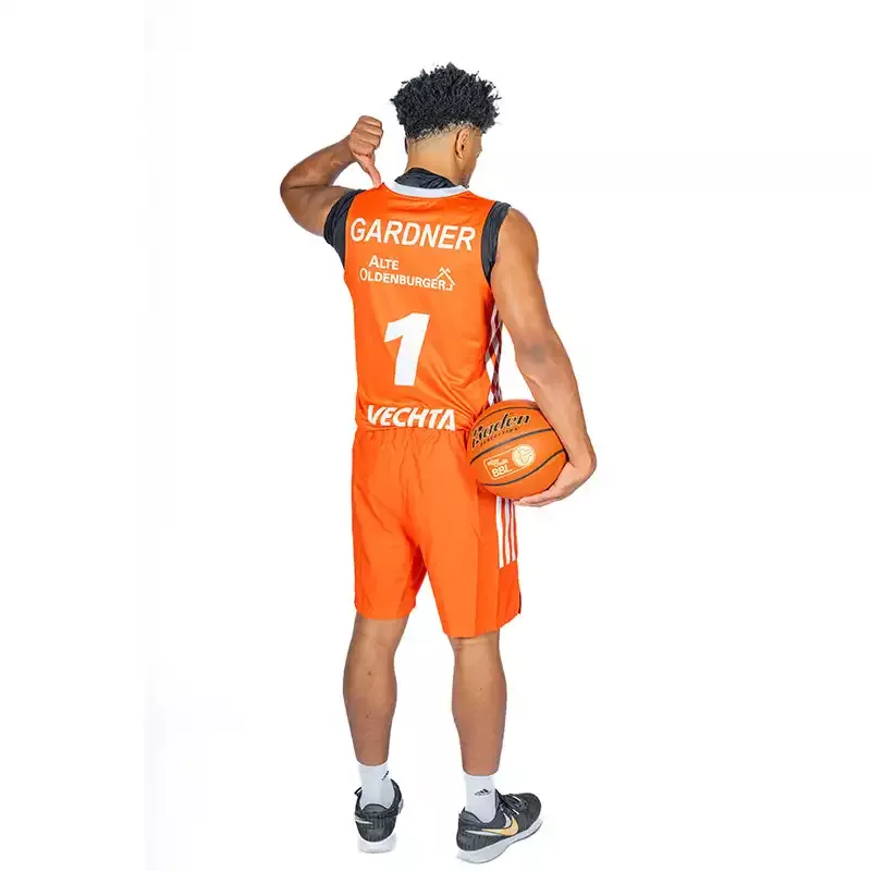 Mann von hinten mit Basketball auf in der Hand im Adidas Trikot "Home" Saison 2024/25 - unveredelt in orange.